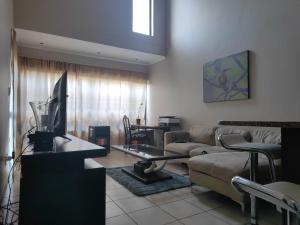 a living room with a couch and a table at Home far away from Home in Roodepoort