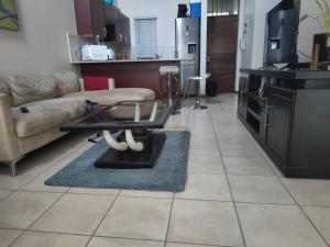 a living room with a couch and a table at Home far away from Home in Roodepoort