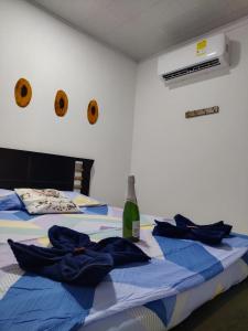 two beds with blue sheets and a bottle of wine at Apartamento la esmeralda! in Puerto Triunfo
