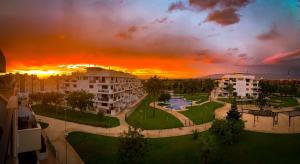 a sunset over a city with buildings and a park at Bajo puerta de Alcazaba in Retamar