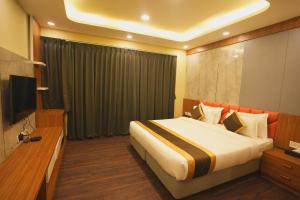 a hotel room with a bed and a television at Hotel CP Palace in Patna