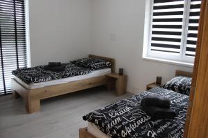 2 camas individuales en una habitación con ventana en Apart U Svatých en Halenkovice