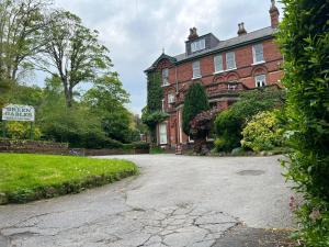 a large red brick house with a driveway at Green Gables Hotel in Scarborough