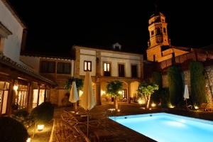 a pool in front of a building at night at Hotel Puerta de la Luna in Baeza