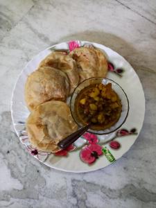 une assiette de nourriture avec du pain et un bol de plongées dans l'établissement Rabindra Bilas Homestay, à Bolpur