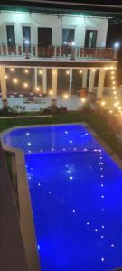una piscina azul frente a un edificio por la noche en Villa Neng Dewi en Cisarua