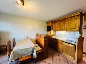 une cuisine avec des placards en bois, une table et un comptoir dans l'établissement Appartement Les Saisies, 3 pièces, 6 personnes - FR-1-293-224, aux Saisies