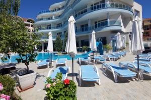 a hotel with chairs and umbrellas next to a pool at Blue Bay Hotel in Sunny Beach