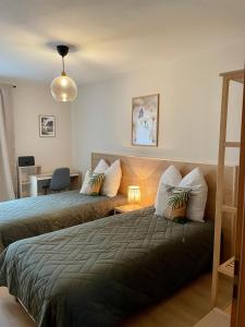 a bedroom with two beds and a table with a chair at Visit Oberhof 3 in Oberhof