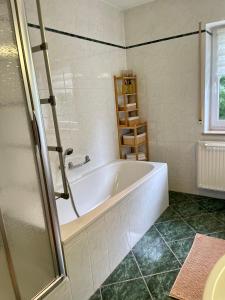 a white bath tub in a bathroom with a window at Visit Oberhof 3 in Oberhof +36 photos