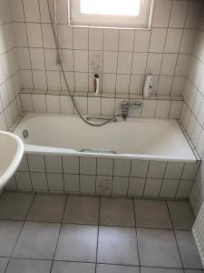 a bathroom with a bath tub and a sink at Laaker Villa nearby outlet Roermond in Ohé en Laak