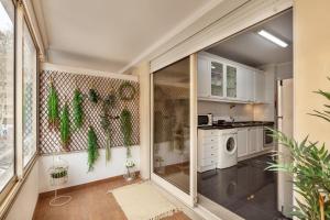 una cocina con una puerta corredera de cristal con plantas. en Apartamento Girassol - Minho's Guest, en Braga