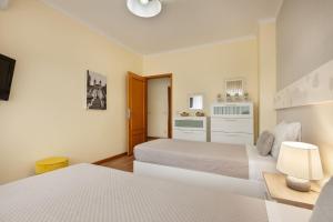 1 dormitorio con 2 camas y mesa con lámpara en Apartamento Girassol - Minho's Guest, en Braga