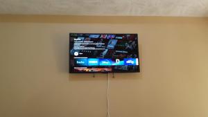 a flat screen tv hanging on a wall at Mango tree Oasis in Treasure Beach