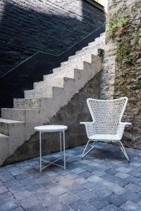 a chair and a table next to a staircase at La Maison du Rivage in Dinant
