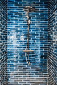 een blauwe douche in een blauwe bakstenen muur bij La Maison du Rivage in Dinant