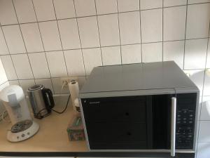- un four micro-ondes installé sur un comptoir dans la cuisine dans l'établissement Laaker Villa nearby outlet Roermond, à Ohé en Laak