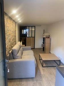 ein Wohnzimmer mit einem Sofa und einem Couchtisch in der Unterkunft Petit endroit paisible in La Roquette-sur-Siagne