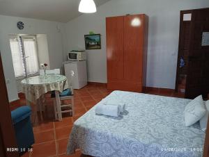 ein Schlafzimmer mit einem Bett und einem Tisch in einem Zimmer in der Unterkunft Casa El Azahin in Cazalla de la Sierra