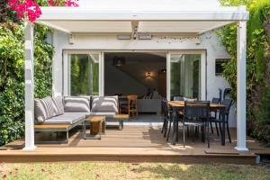 une terrasse avec un canapé, une table et des chaises dans l'établissement Luxury townhouse capricho golden mile, à Marbella