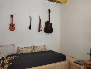 a bedroom with guitars hanging on the wall at Artist Rooms - Triantafyllou Birth House in Kefalos