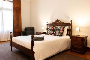 a bedroom with a large bed and a chair at Fradelos Porto Centro in Porto