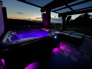 a hot tub with purple lights on a deck at Holiday Home Ernest Železni with hot tub in Ivančna Gorica