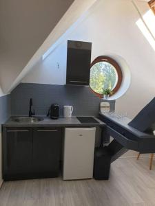 una pequeña cocina con fregadero y ventana en Studio moderne à Vieux- Thann avec parking privée, 
