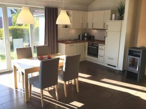 a kitchen with a dining room table and chairs at Ferienhaus Müritzhus an der Müritz in Marienfelde +14 photos