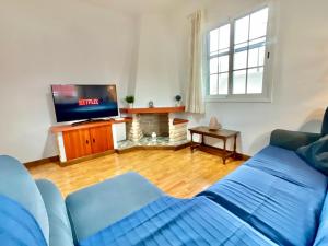 sala de estar con sofá azul y TV en Big&Confort ''con terraza y jardín'' en Tegueste