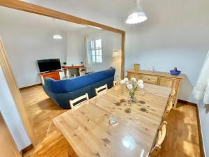 sala de estar con mesa y sofá azul en Big&Confort ''con terraza y jardín'' en Tegueste