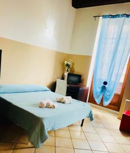 a bedroom with two towels on a bed at Appartamenti Le Rondini in Cagliari