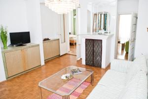 un soggiorno con divano bianco e tavolo in vetro di Gabriele´s Apartment a Vienna