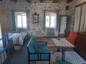 a bedroom with a bed and a table and a bed and a room at 19th century stone house on the seashore in Radovići