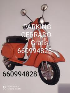uma fotografia de uma scooter vermelha num cartaz em Apartamento Alcázar parking incluido VU-TERUEL-18-035 em Teruel