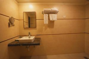 a bathroom with a sink and a mirror and towels at Hotel CP Palace in Patna +37 photos