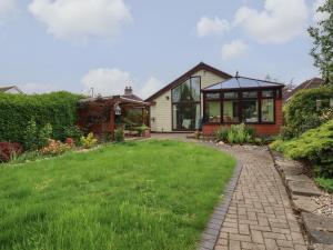 a house with a conservatory and a grass yard at 256 London Road in Colchester