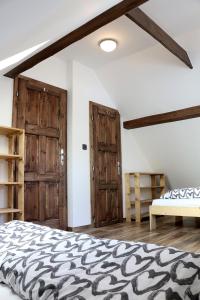 ein Schlafzimmer mit einem Bett und zwei Holztüren in der Unterkunft Apartmán Pod střechou - Jelení chata Skladanka in Lučany nad Nisou