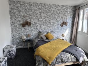 una camera da letto con un letto e carta da parati floreale di Charmante maison à Rouen a Rouen