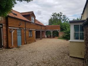 an exterior view of a wooden house with a patio at The Barn, Norwich in Norwich