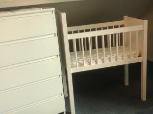 a white crib with a dresser next to it at Laaker Villa nearby outlet Roermond in Ohé en Laak