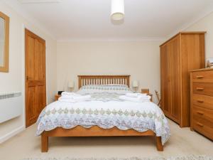 a bedroom with a large bed with wooden furniture at Godrevy Barn in Hayle