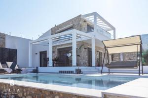 a villa with a swimming pool and a patio at ELIA STONE VILLAS in Skala Prinou