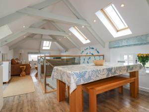 a kitchen and living room with a table and skylights at Trerubies in Delabole