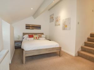 a bedroom with a bed in a room with stairs at Trerubies in Delabole