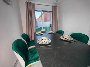 une salle à manger avec une table noire et des chaises vertes dans l'établissement Tyburn Home, Birmingham with FREE Parking, à Birmingham