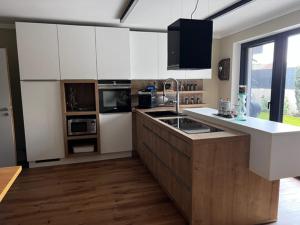 a kitchen with white cabinets and a counter top at Heidis Ferienwohnung in Kramsach