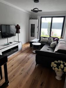a living room with a couch and a flat screen tv at Heidis Ferienwohnung in Kramsach