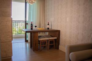 a kitchen with a table with two bottles of wine at Flat 333 - Luxo e Vista da Pedra Azul in Pedra Azul