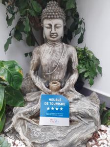 Les 3 Soleils في سانت-جوزيف: تمثال بوذا قعد على شجر